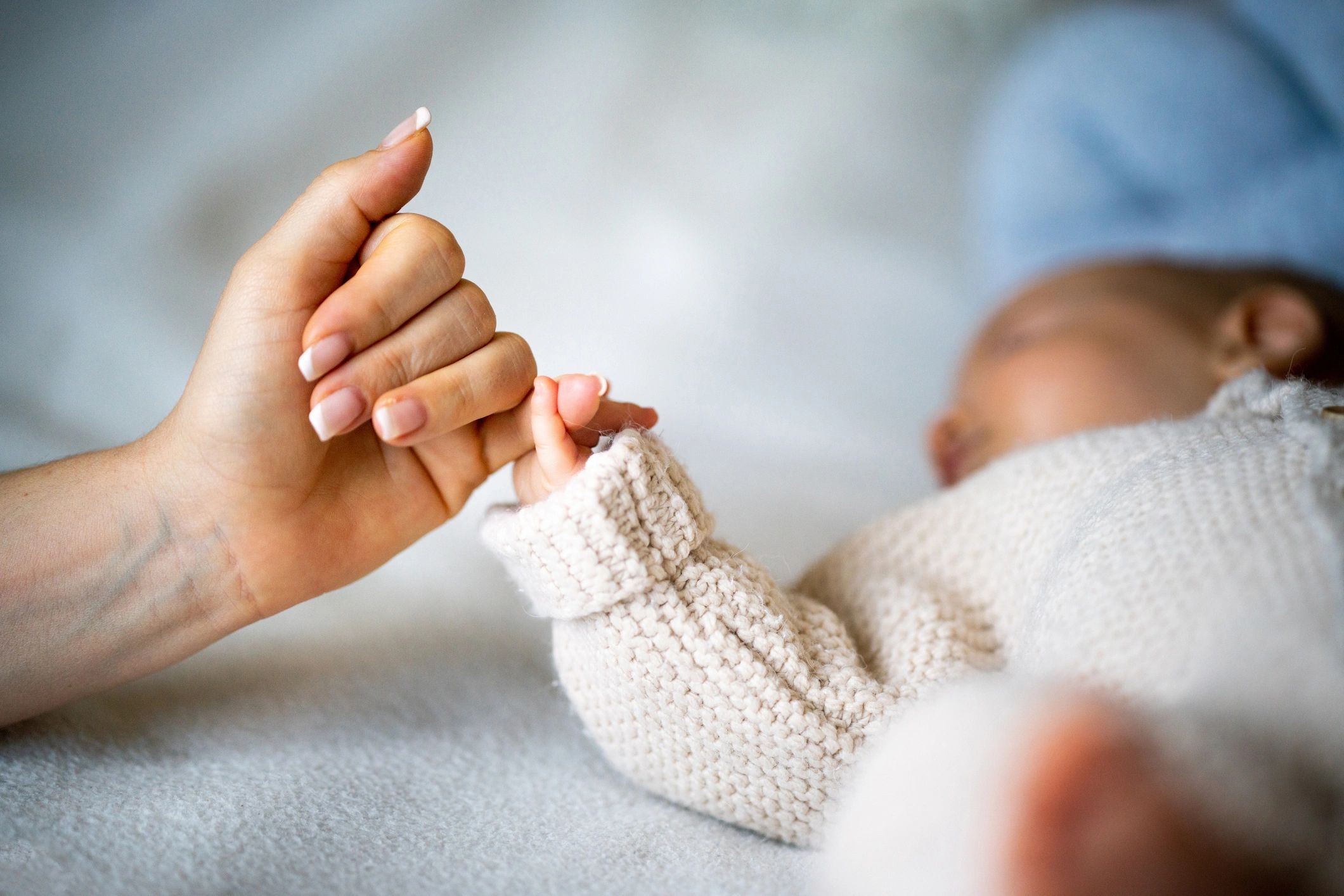 Parent holding a newborn's hand