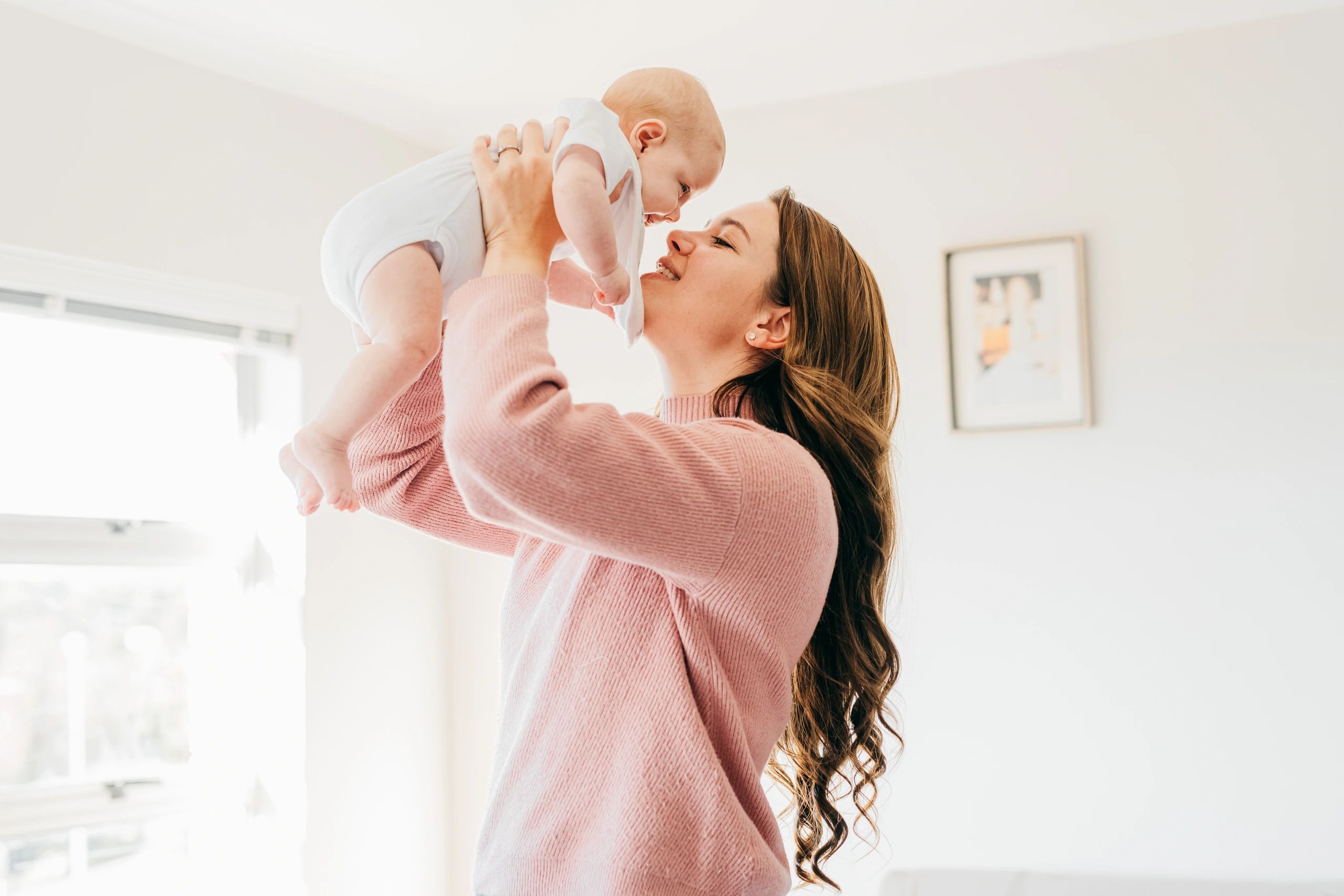 Mother holding her newborn in soft natural light