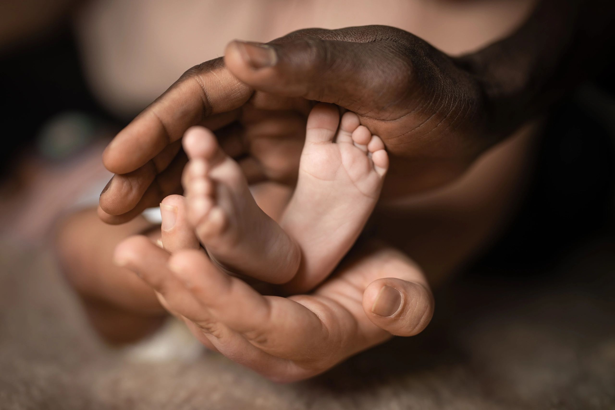 Family holding baby feet together