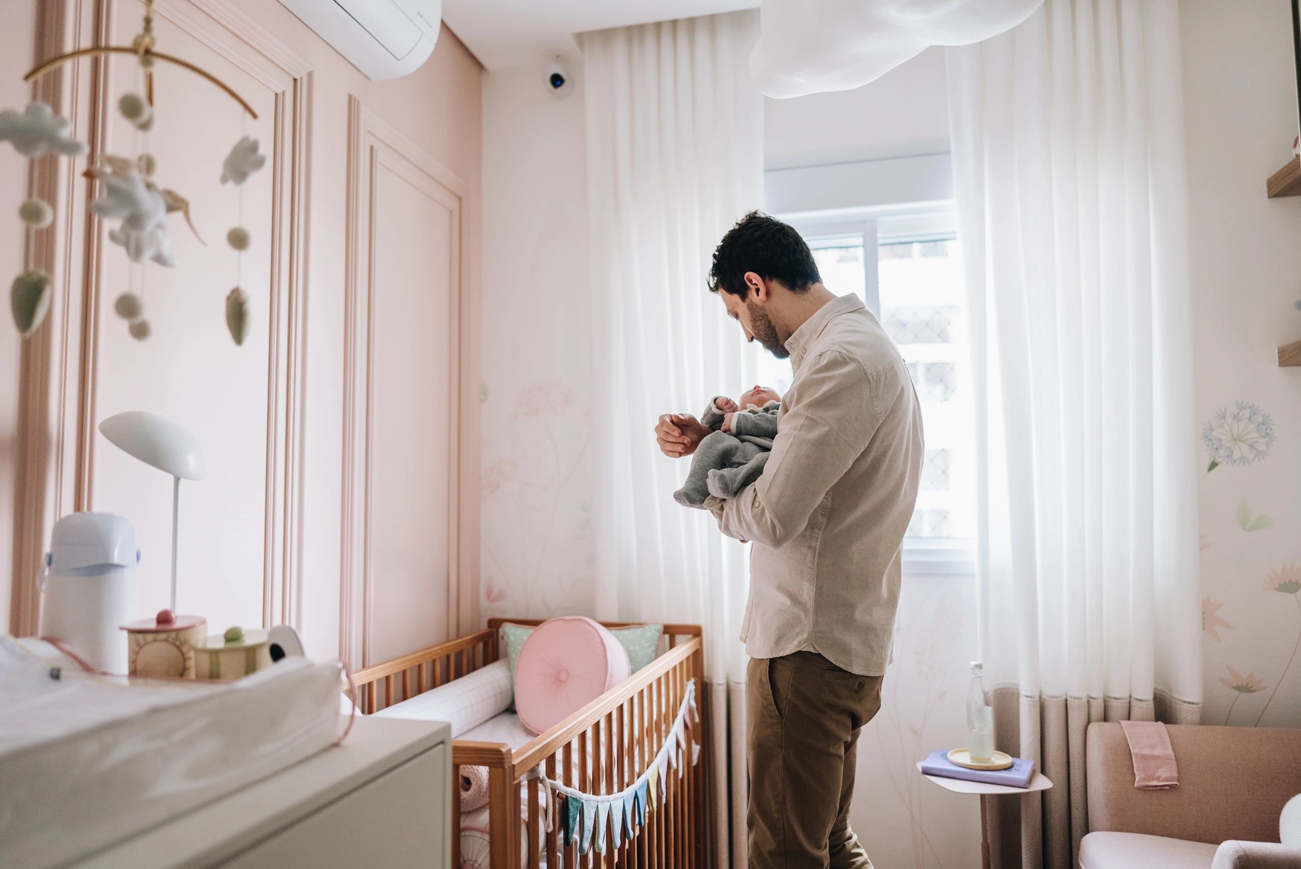 Parent holding a newborn in a bedroom
