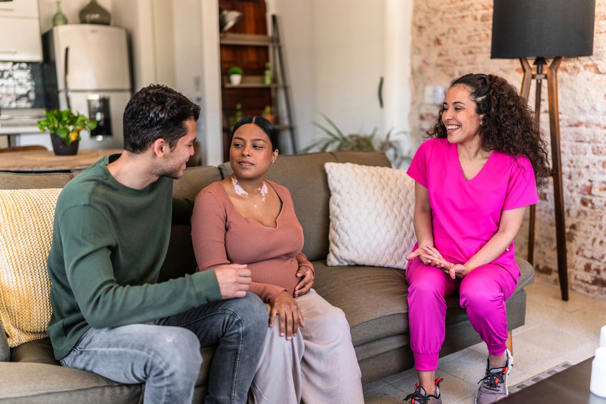 Nurse speaking with expecting parents in a home setting