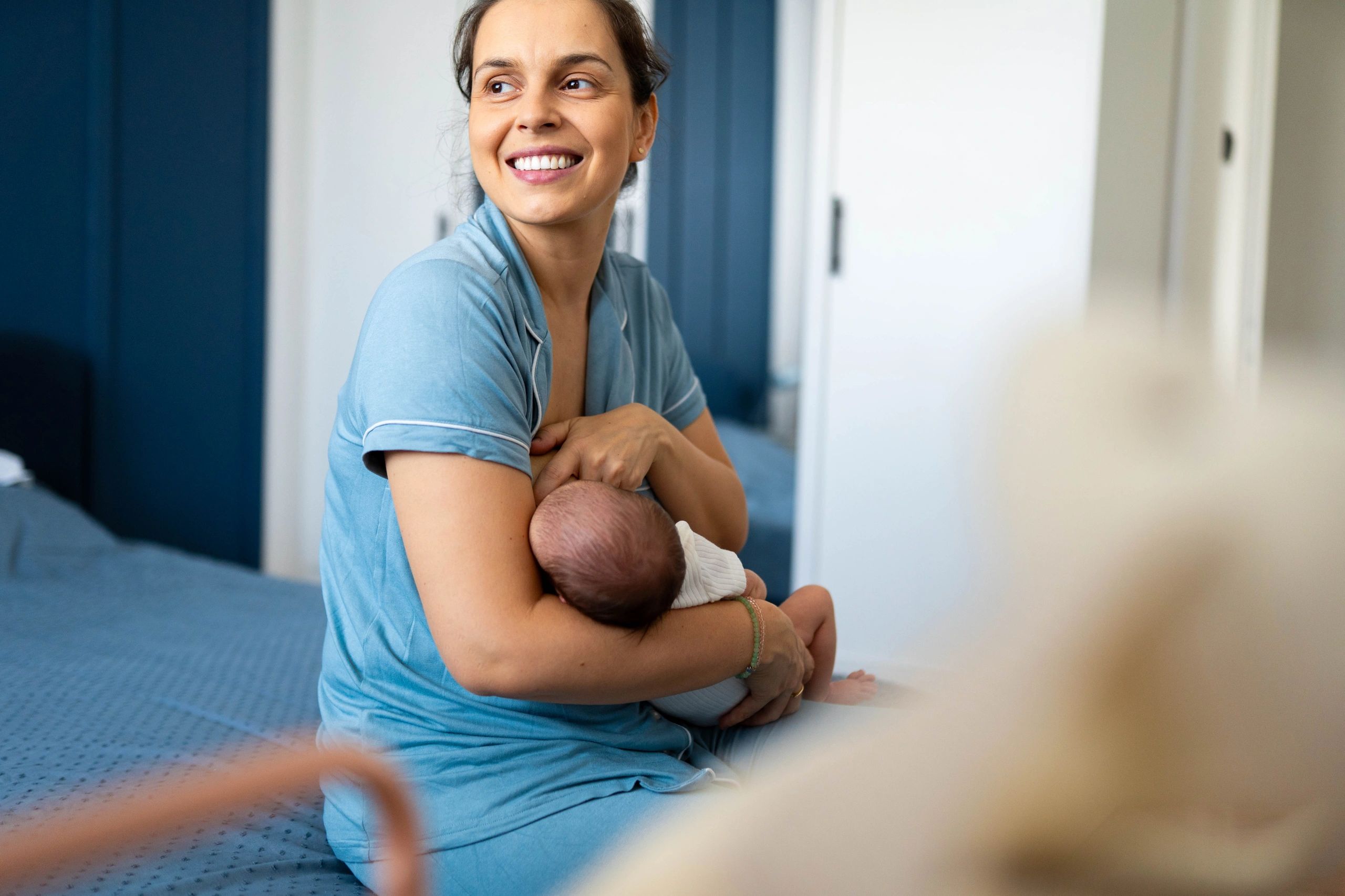 Mother breastfeeding her newborn at home